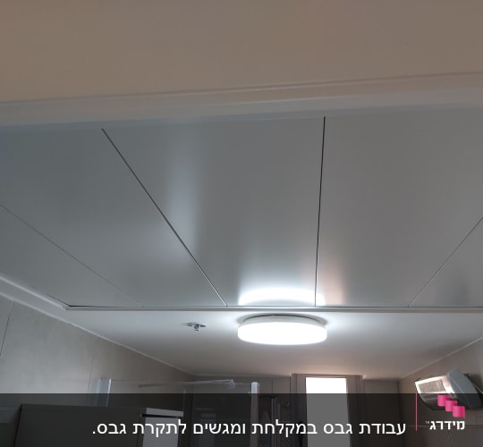 תקרת גבס עם תאורה עגולה ומזגן קיר